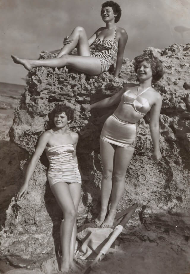 A black and white image of three women at the beach in the 1950s.