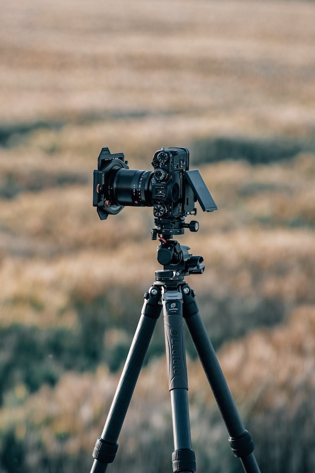 A tripod with a camera mounted on top. 