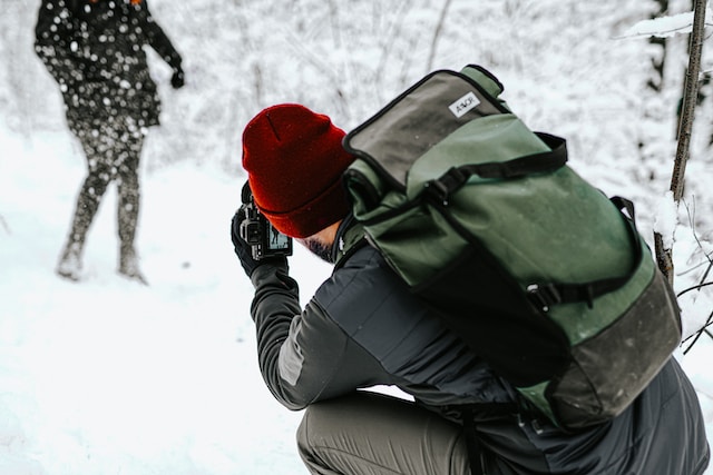 A photographer in the snow trying to capture the perfect shot.
