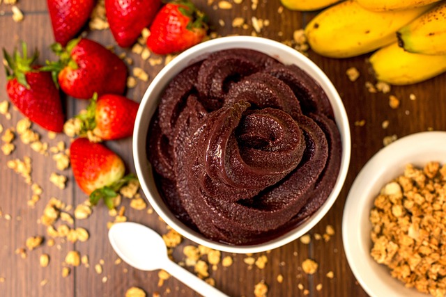 A bowl of acai smoothie with strawberry and banana on the side.