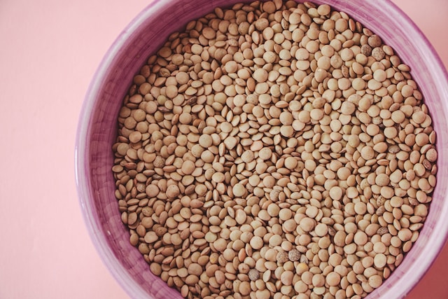 Raw lentils inside a pink bowl