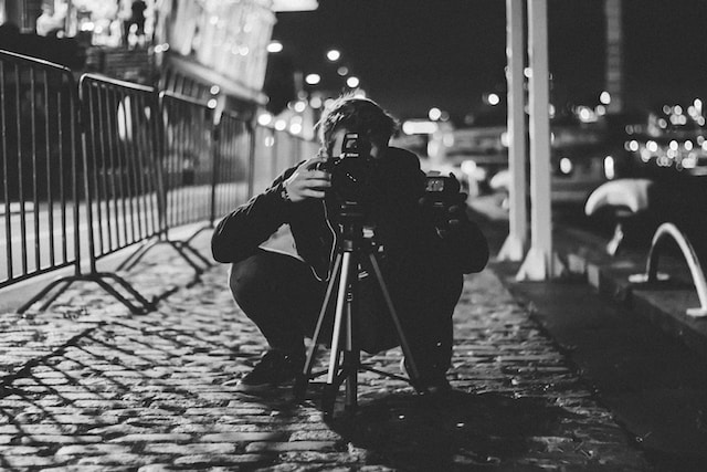 A street photographer peering into his camera.