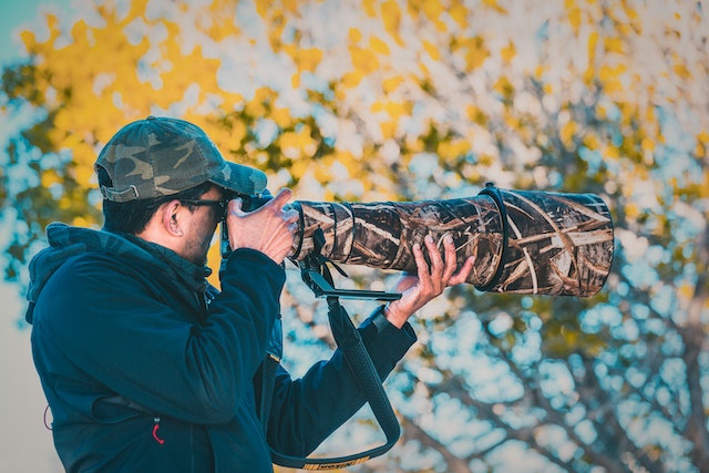 A guy using a camouflaged camera equipment