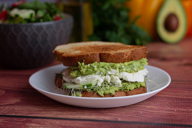 An avocado sandwich served on a white plate.