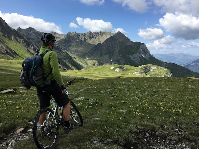 Person wearing a backpack riding a bike, looking at the terrain ahead