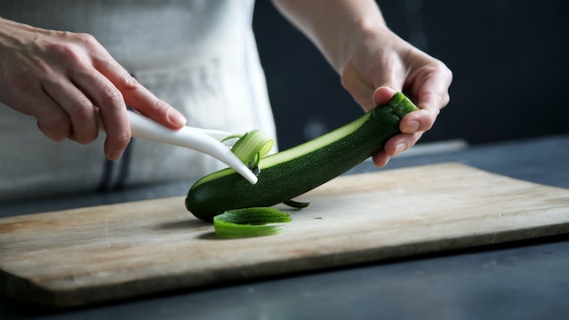 Person peeling a zucchini