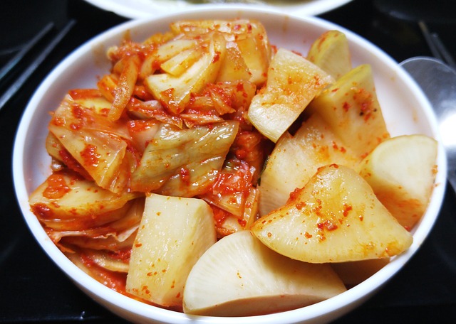 Napa cabbage and radish kimchi in a white ceramic dish