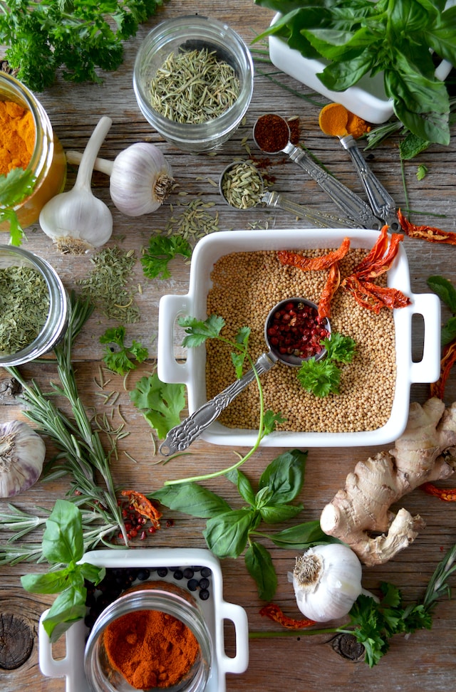 An assortment of grains, spices, and herbs on a wooden tables