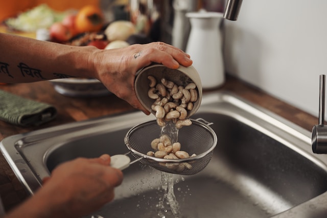 Person holding a strainer to drain beans 