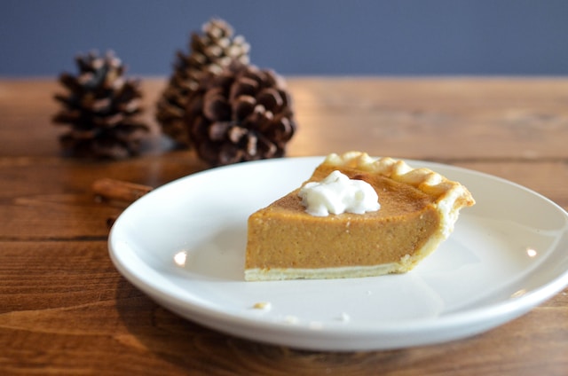 A slice of pumpkin pie with whipped crea, on top