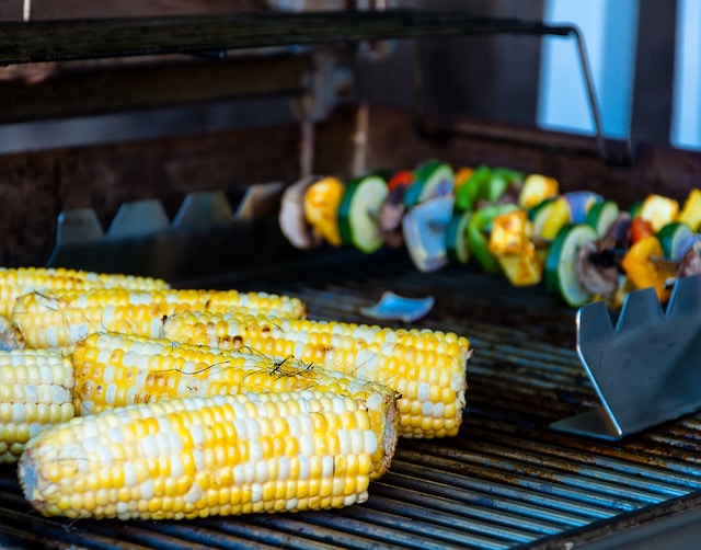 Corn and skewered vegetables on a grill