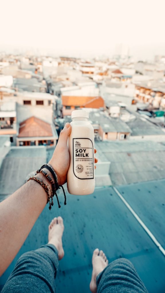 Person holding a bottle of soy milk