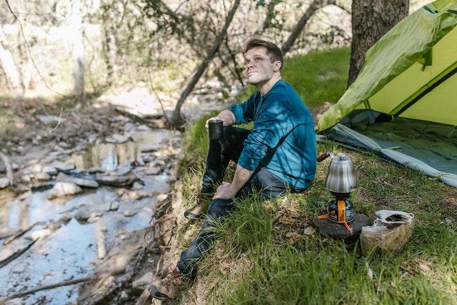 Man camping beside a stream